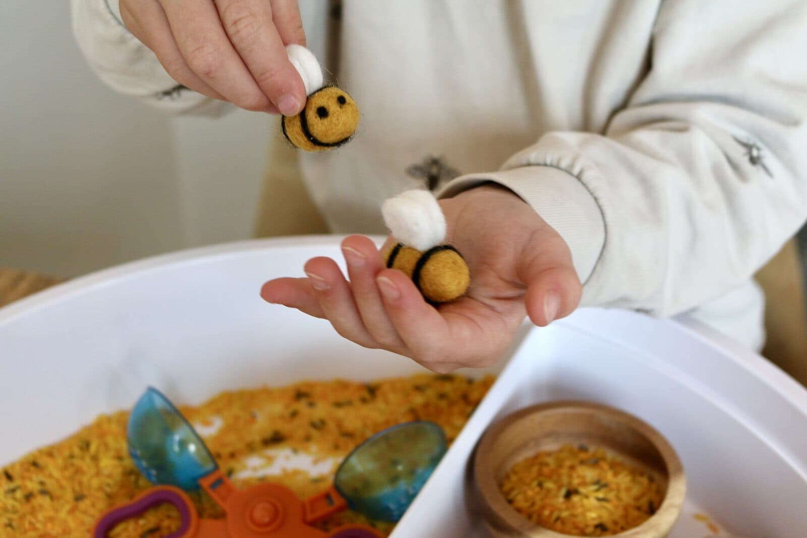 Kinderhandjes met vilten bijtjes boven rijsttray